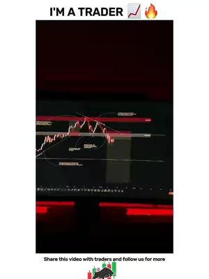 The image shows a dark screen displaying a financial chart, with red and white lines indicating stock movements. The top part of the screen also displays overlaid text: "I'M A TRADER", along with icons for a rising graph and a fire symbol. The bottom border has a tagline that reads "Share this video with traders and follow us for more".