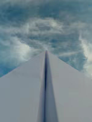 The image has a perspective view of a white paper airplane against a cloudy sky. The plane's surface is smooth and pristine, with a sharp central crease splitting its symmetrical form. The sky is filled with soft, diffused clouds in shades of blue and white, creating a serene backdrop to the plane.