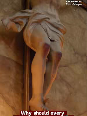 The image shows a detail of a sculpted figure of Jesus on the cross. The focus is on the legs and lower torso, highlighting the wounds and the cloth draped around the waist. The lighting is dim, with shadows creating depth and texture on the stone or plaster material.