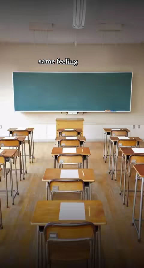 An empty classroom with rows of desks facing a blackboard. The lighting is neutral, and the room is devoid of people, but with the text overlayed on the image, it might imply the creator is missing it