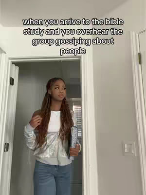 A young woman stands in the doorway of a bright, neutral-toned room. She has long, wavy hair and wears a white top, silver jacket, and blue jeans. She's holding a book and appears to be looking to her side with a thoughtful expression. The doorway frames her, and text overlays the image above her, setting the scene.