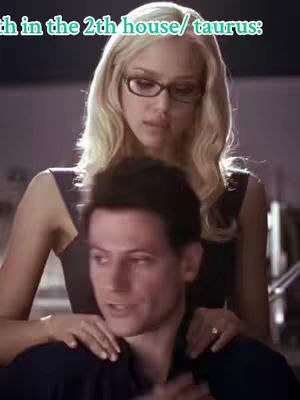 The cover image features a woman with blonde hair and glasses in a close-up shot, looking down at a man whose face is partially visible in the foreground. Text is overlaid at the top, and the background has blurry interior details. The composition suggests a scene between two people.