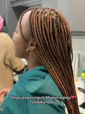 The cover image offers a side view of a woman with long, intricately styled braids. Her head is turned slightly towards the left, and she faces away from the camera. She is wearing a dark green hoodie. In the background, another person is partially visible, near what seems to be a kitchen setting. Text overlay with a message in a script font appears at the bottom.