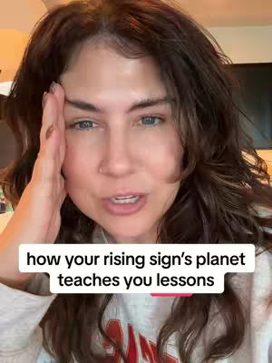 The cover image shows a woman up close, her face and upper body in view. She has dark brown, shoulder-length hair. Her expression is emotive, with her right hand touching her temple. Beneath her face, a white rectangle overlays, displaying the text "how your rising sign's planet teaches you lessons". The overall lighting appears to be soft and natural.