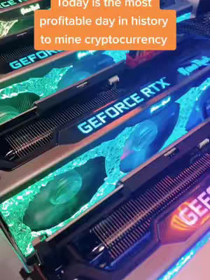 The cover image shows several graphics cards with a text overlay. The graphics cards are arranged in a row, angled towards the viewer. The cards have dark casings with the text 'GEFORCE RTX' illuminated in blue. The space between the cards is filled with a teal, watery effect. The text overlay is in an orange box near the top and reads, 'Today is the most profitable day in history to mine cryptocurrency.' The overall composition is vibrant, with a cool color palette and a close-up perspective.