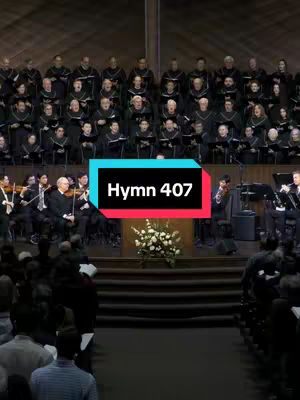 The image shows a church choir and orchestra performing. A rectangular overlay with text "Hymn 407" is imposed on the middle of the scene. The setting appears to be a large, formal church with a tiered seating arrangement for the audience.