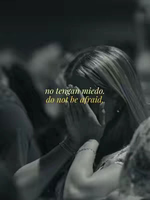 A grayscale image shows a person with long hair, seen from the shoulders up, with hands clasped together and appearing to cover the face in prayer or contemplation. Text in a yellow font is overlaid, centered on the image.