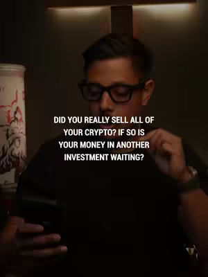 A man wearing glasses looks down while holding a phone with text overlayed on the image. The text is white with a black gradient, and the background is dim. The man is wearing a black shirt, and in the background there is a blurred object that appears to be a lamp. The overall composition is designed to be simple and informative.