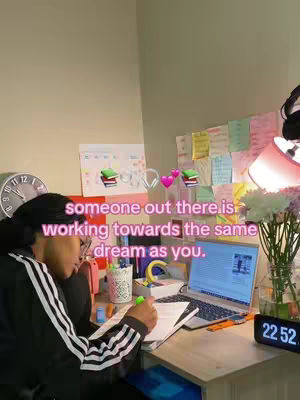 A person is studying at a desk with a laptop, notes, and other study materials. Text overlays the image, indicating encouragement and motivation. Soft lighting and a neutral background provide a cozy atmosphere to the scene.