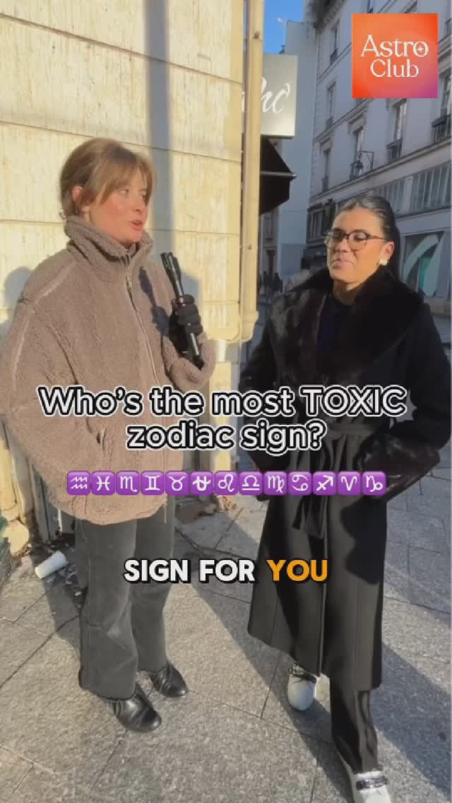 Two women are standing outside, likely on a city street. The woman on the left wears a brown sherpa-style jacket and holds a black microphone. The other woman, on the right, wears a black coat and glasses. Text overlays read "Who's the most TOXIC zodiac sign?" and "SIGN FOR YOU"