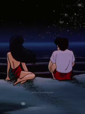 An anime-style illustration depicts a couple sitting side-by-side, gazing at a starry night sky. A woman with long dark hair and a red and green outfit sits on the left, while a man in a white shirt and red shorts sits on the right, both facing away from the viewer. The scene is set near water, with the dark sky filled with stars creating a romantic ambiance.