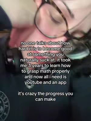 A selfie-style shot of a person with glasses, their face partially visible, with several lines of white text overlayed on the image. The person appears to be in a dimly lit setting.
