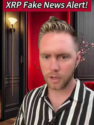A man with light-colored hair and a striped shirt is centered in the image. Above him is a red-maroon banner and a red-maroon curved wall. A lamp and some floral decoration are also vaguely visible on the opposite side.
