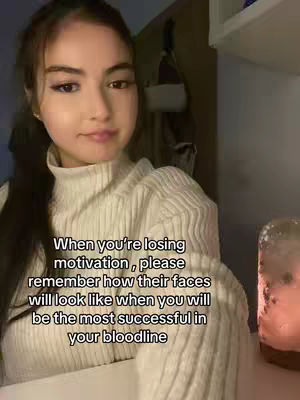 A young woman with dark hair and a white sweater is positioned in a slightly out-of-focus setting. Text overlays the image, offering motivational words about the importance of ambition and success.