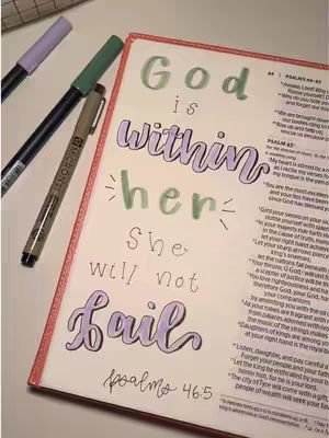 A photo of a bible, open to a page with colorful hand lettering. Three markers are placed next to it.