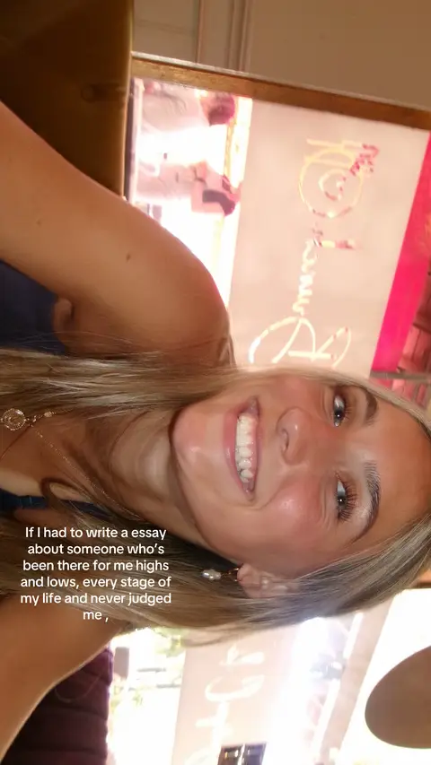A young woman with long, light-blonde hair smiles widely, looking directly at the camera. She's in a well-lit indoor space, with a glimpse of a restaurant's interior or a similar setting in the background. The text overlay indicates a personal reflection about a supportive individual.