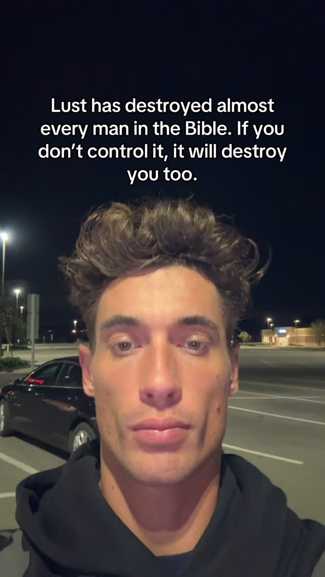 A selfie-style shot of a person against a blurred outdoor background at night. The person is in the foreground, looking directly at the camera with a serious expression. Text overlays the top of the image. The background is dark, with a street, streetlights, and a car.