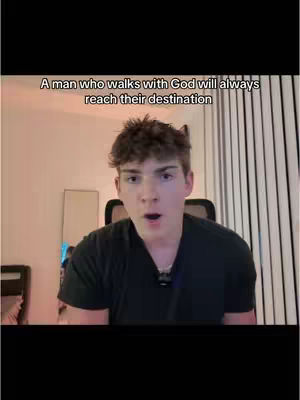 A young man with short, curly brown hair stares directly at the camera with an open mouth, seemingly in mid-sentence, against a softly lit interior setting. Above him, overlaid on black text, reads: 'A man who walks with God will always reach their destination.' The background includes vertical blinds and a partially visible mirror, suggesting a home or office. The image has a simple, straightforward composition, focusing attention on the man and the message.