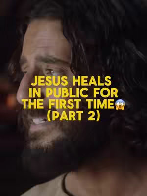 The cover image shows a close-up shot of a man from the chest up, presumably Jesus, with long dark hair. The man is looking slightly to the left, and the lighting suggests a warm, indoor setting. Overlaid on the image in a yellow font is the text: "JESUS HEALS IN PUBLIC FOR THE FIRST TIME (PART 2)". The text has a drop shadow, making it stand out, and is placed prominently in the top center of the image. The overall composition focuses on his face.