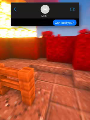 The image shows a Minecraft-style scene including a digital text message overlay. The foreground features a textured wooden fence with orange hues, positioned at an angle. Behind the fence, there is a floor made of red bricks. In the background are two large, pixelated red structures that resemble buildings. The Minecraft aesthetic with blocky textures is clear in all elements, and the scene is subtly blurred in parts to suggest background depth. A text message notification at the screen's top, features a contact labeled 'Mom' and the message bubble 'Can I call you?'.