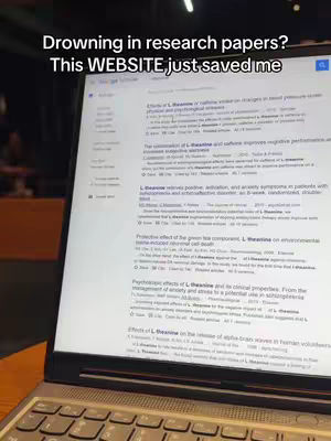 A laptop screen displays search results for academic papers, with overlaid text at the top. The screen dominates the composition, illuminated by the ambient light of the setting. The keyboard sits at the bottom of the frame.