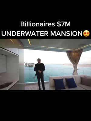 The cover image shows a well-dressed man standing inside what appears to be a luxurious modern living room, with a large window offering a scenic view of the ocean. The text overlay indicates this is a luxurious underwater mansion.