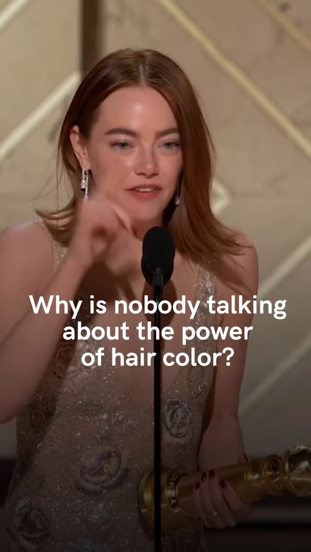 The image shows actress Emma Stone, mid-speech, holding a Golden Globe award. Text overlayed asks, 'Why is nobody talking about the power of hair color?'