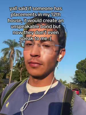 A selfie-style video cover image. The image is a medium shot of a young man with light skin, glasses, and short dark hair. He is facing forward, slightly offset to his left, with a neutral expression. He is wearing a blue long-sleeve shirt and has a backpack. He also sports white earbuds. Palm trees and a red car are visible in the background. Text is overlayed on the upper portion of the image in a white sans-serif font.