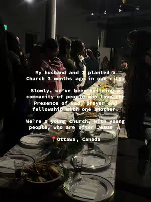 An image shows a long table set for a meal, presumably a church gathering. People are standing around the table, engaged in conversation. The lighting is dim, creating a warm atmosphere, and the focus is on the fellowship and community.