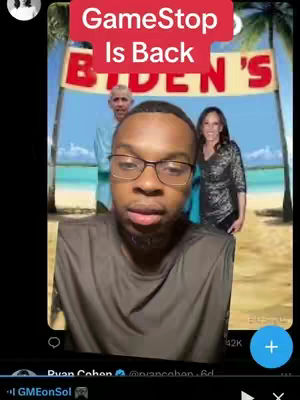 A wide shot showing a man wearing glasses looking towards the camera with a background of two figures and a beach scene. Overlaying text reads, GameStop Is Back, in red on a pink banner. The background scene shows two figures next to a banner with text. The scene appears to be a beach or outdoor theme with a blue sky