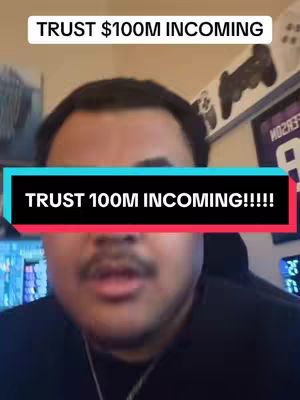 A man with dark hair and a mustache is centered in the frame. The background shows a messy room with objects like what appear to be game controllers on the wall. Overlayed on the man's face is a black rectangle with white text and a smaller cyan rectangle below with more text. Above him a white rectangular with text that can be seen. The lighting is somewhat dim.