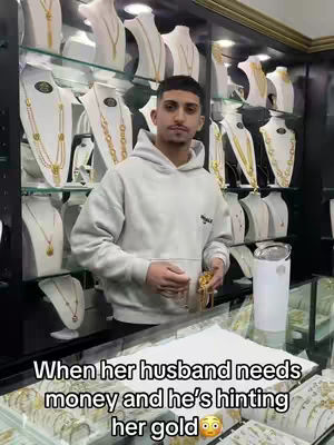 The cover image shows a man standing in a jewelry store. He's wearing a light gray hoodie and holding a piece of gold jewelry. Behind him, showcases filled with gold necklaces and pendants create a backdrop. The store has a well-lit, professional appearance, typical of a jewelry retail setting. The composition is straightforward, focusing on the man as the central figure.