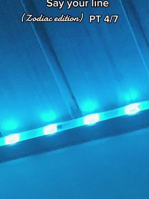 The image is a low-angle shot of a ceiling covered in sections and illuminated with teal LED strip lights. The lights run horizontally across the image and give off a diffused glow. The background and ceiling sections are a darker shade of blue or teal. Text overlays are added near the top of the image.