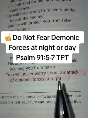 A hand holding a pen points to a highlighted Bible verse, with a superimposed text overlay. The image is a close-up of an open book with text, a pen, and a text overlay. The color palette is muted, dominated by white and beige of the book and dark black of the pen and text. The layout is focused, with the highlighted text and the overlay dominating the visual space.