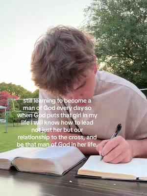 A person is sitting at a table with a book and a notebook, writing with a pen. The background suggests a sunny outdoor location. Text is overlaid on the image, describing the person's journey of faith and commitment.
