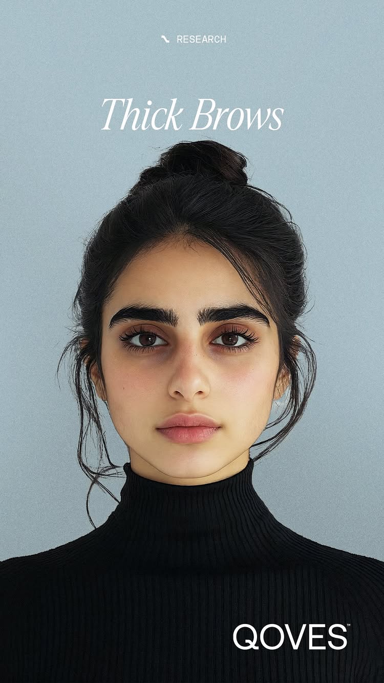 A portrait of a young woman with dark hair styled in a loose bun, wearing a black turtleneck. She has prominent, thick dark eyebrows. The background is a solid, soft blue-gray. Text overlays include 'RESEARCH' at the top and 'Thick Brows' in a stylized font.