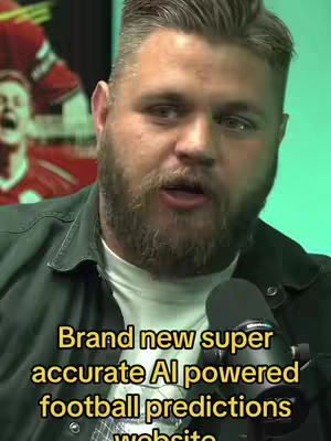 A man with a beard and dark hair stands in front of a microphone, speaking. The background is a blurred-out image of a sports setting with a person in a red jersey visible. Text overlayed is in yellow font, indicating the video content.