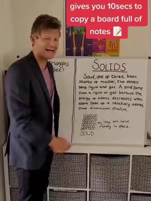 A man in a blazer and pink shirt stands next to a whiteboard with handwritten notes about solids. A red rectangle at the top of the image contains the text describing the time given to copy the board notes.