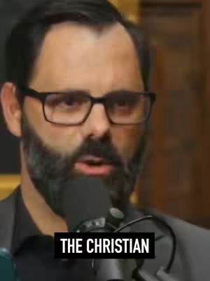 The cover image is a medium shot of a man wearing glasses and a dark suit, with a microphone positioned close to his mouth. He has a full beard and is looking slightly off-center, appearing to be speaking. The background is a blurred mix of brown and gold tones, possibly a wall or paneling. The phrase 'THE CHRISTIAN' is superimposed in a black box at the bottom of the image.