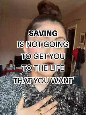 A woman is centered in the frame, looking directly at the camera. Text overlays the image. Her hair is styled in a top bun. She wears a patterned jacket and a gold ring. Behind her, parts of an interior space are visible.