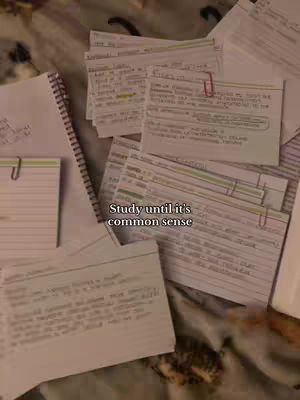 A top-down shot of a study setup, featuring several index cards and a spiral-bound notebook scattered over a soft, patterned surface. The cards, filled with handwritten notes, are held together with paper clips. The background is a neutral color, the notes are filled with the text for the study. A text overlay is added at the bottom