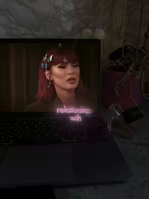 The cover image shows a laptop displaying a video of Megan Fox. Overlaid on the laptop screen is the text overlay of the video title. The laptop is placed on a surface with a textured pattern, and a plant and other items add to the setting.