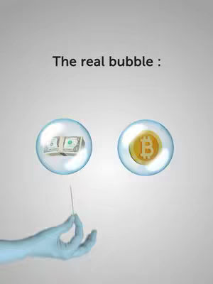 The image presents a light gray gradient background. In the center, the text 'The real bubble:' is displayed in black. Below this, two bubbles are positioned; the left bubble contains a stack of US dollar bills, and the right bubble holds a Bitcoin symbol. A hand, adorned in a blue glove, holds a needle pointing towards the bubbles.