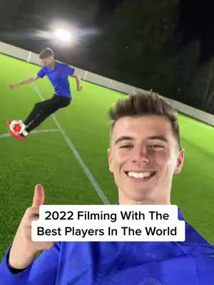 The cover image features a smiling young man in a blue shirt giving a thumbs up. In the background, a soccer field scene is partially visible, with another person kicking a soccer ball. The text overlay reads: "2022 Filming With The Best Players In The World".