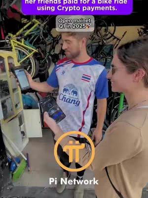 A man and a woman are standing next to each other, smiling. The man holds a tablet and a phone with an interface related to cryptocurrency. The woman looks towards the camera. The background includes bicycles and a shop setting. The Pi Network logo is prominently displayed.