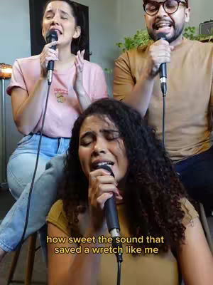 The cover image shows three people singing into microphones. The focus is on a woman in the foreground with curly hair singing with her eyes closed. The background has two other people singing, and the text overlay appears to be lyrics.