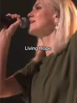 A woman with blonde hair is singing into a microphone. She is wearing a green top. The words “Living Hope” are overlaid on the image.