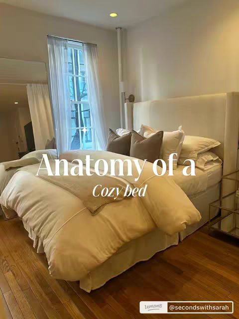 The cover image shows a light-filled bedroom with a large bed as the focal point. The bed is made with white bedding and multiple pillows, creating a fluffy and inviting appearance. Natural light streams in from a window, illuminating the room. Text overlays, "Anatomy of a Cozy bed", and "Cozy bed" are added to the image.