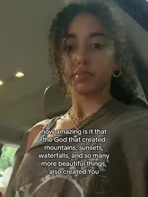 A medium shot features a young woman with curly hair, gazing slightly upward. She's in a car interior, and the text overlays a portion of her upper body. The color palette is muted, with the woman's skin tones and the car's interior dominating.