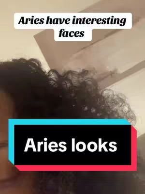 A selfie style image featuring a woman's curly black hair framing her face, with the upper portion including text: Aries have interesting faces. Below, a layered rectangular text box says Aries looks.